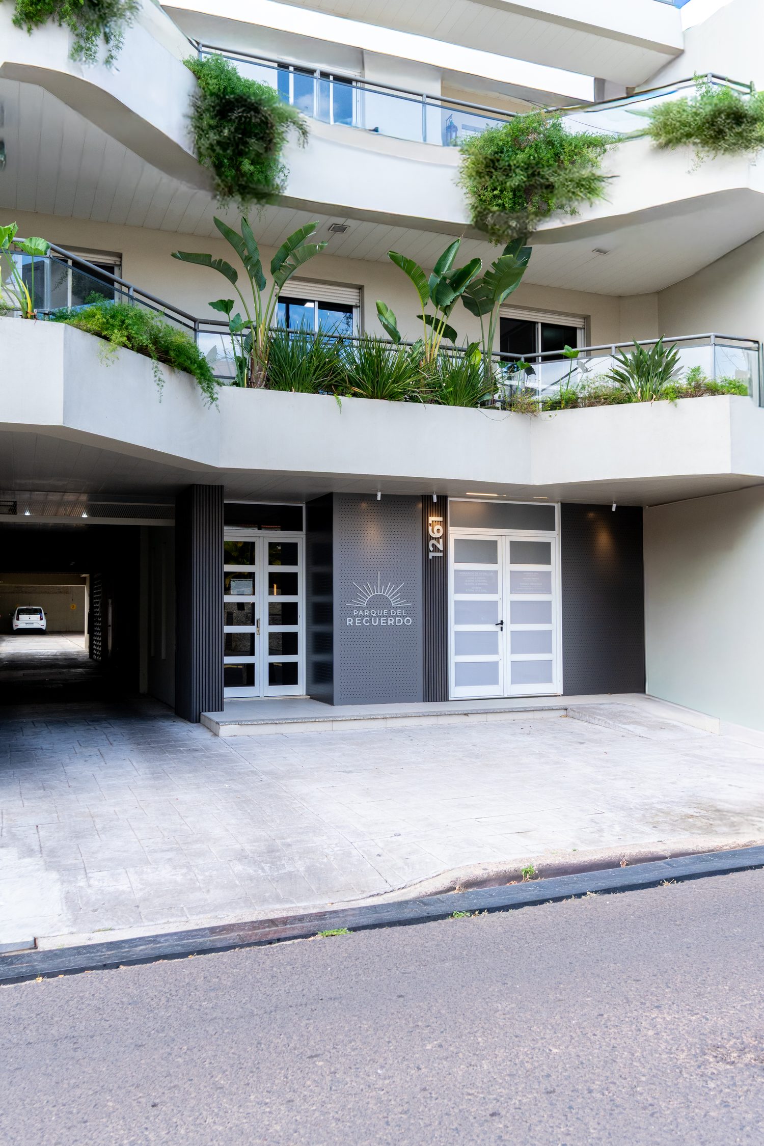 Edificio Entre Ríos en Corrientes: acceso con paneles perforados bajo el alero con jardineras