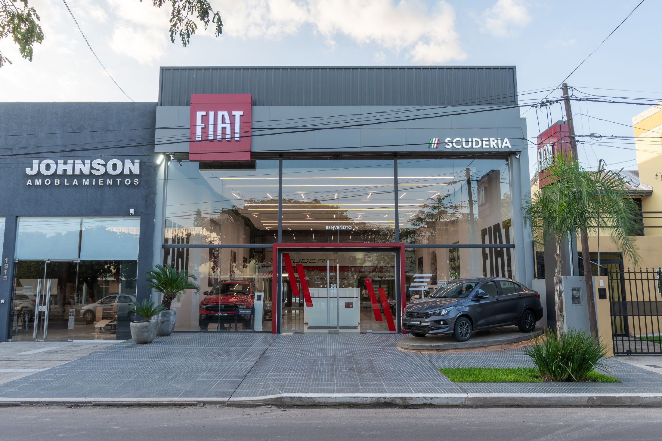 Concesionaria Fiat Sarmiento en Resistencia: frente vidriado de doble altura con el acceso enmarcado en rojo